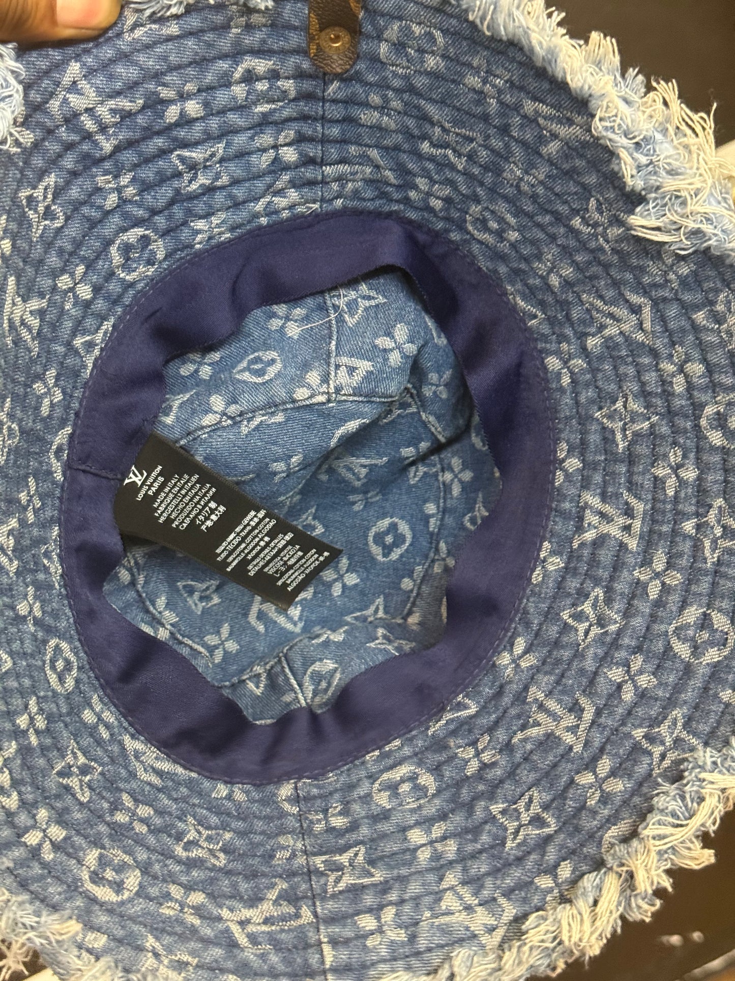 LV Monogram Denim bucket hat features a blue monogram pattern and frayed edges