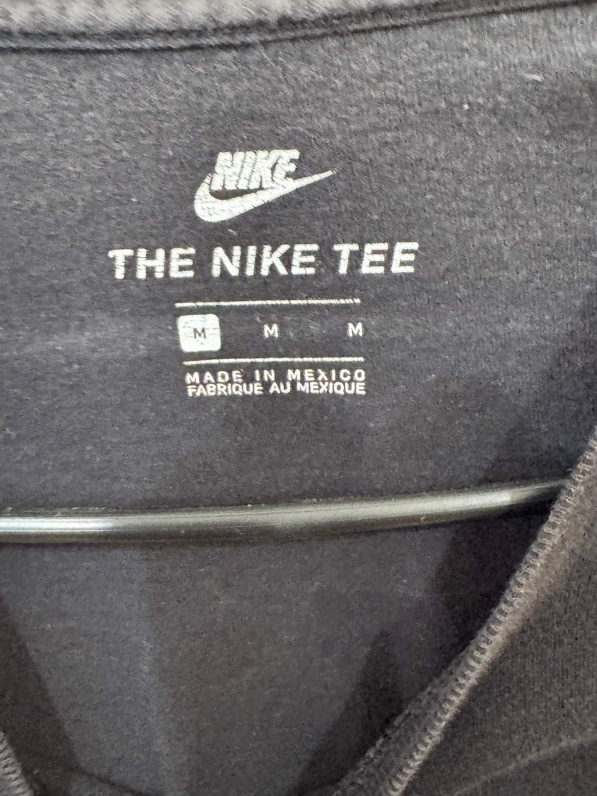 black Nike t-shirt features a large white swoosh logo size medium
