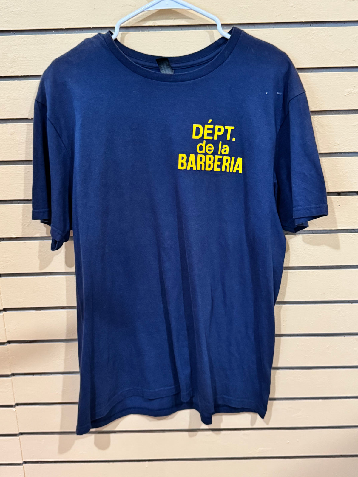 blue cotton graphic t-shirt size large featuring the yellow text "DÉPT. de la BARBERIA" printed on the back