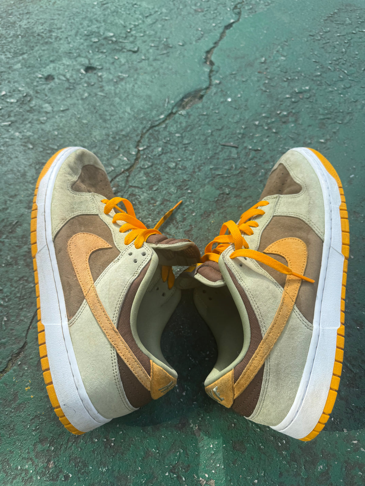 Nike Dunk Low 'Dusty Olive,' size 12 featuring a rustic brown suede base with olive overlays and bright orange laces.