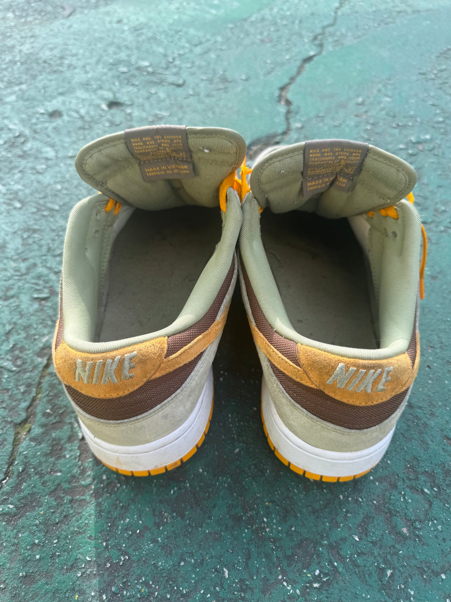 Nike Dunk Low 'Dusty Olive,' size 12 featuring a rustic brown suede base with olive overlays and bright orange laces.