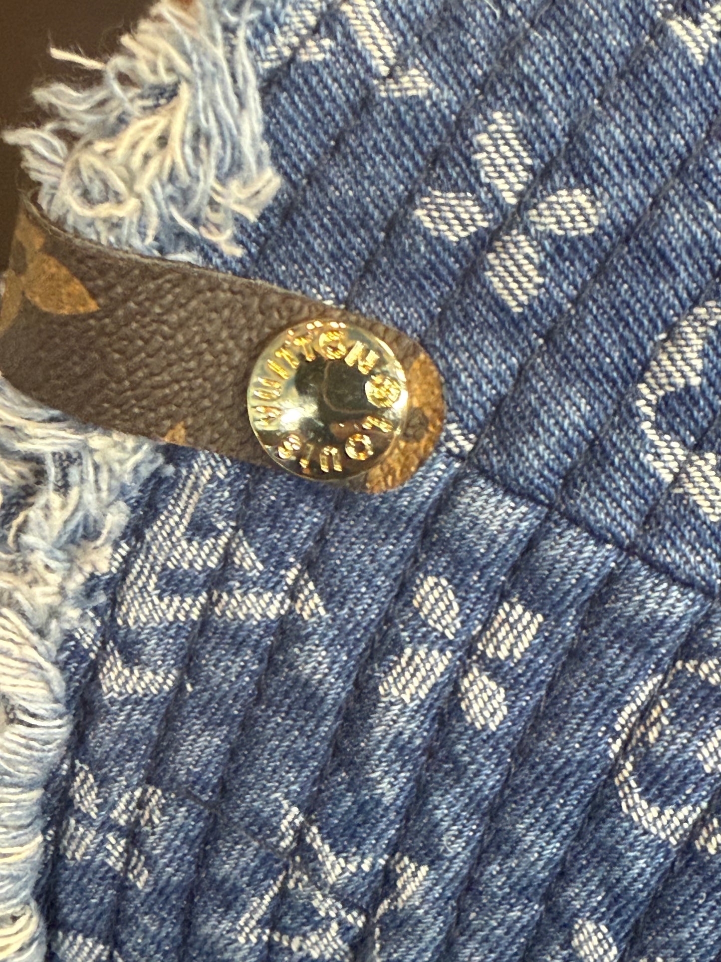LV Monogram Denim bucket hat features a blue monogram pattern and frayed edges