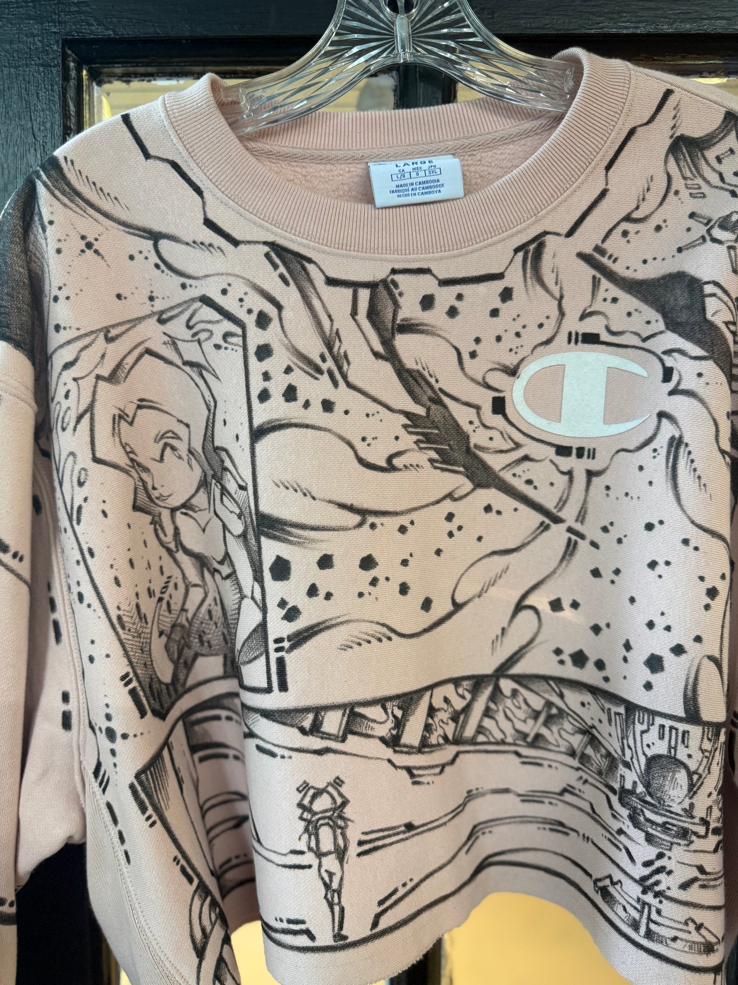 Champion Light Pink cropped crewneck sweatshirt, featuring an all-over black-and-white comic book panel manga sketch