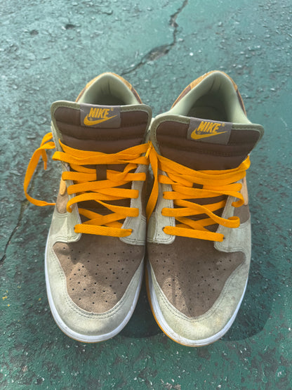 Nike Dunk Low 'Dusty Olive,' size 12 featuring a rustic brown suede base with olive overlays and bright orange laces.