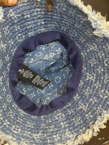 LV Monogram Denim bucket hat features a blue monogram pattern and frayed edges